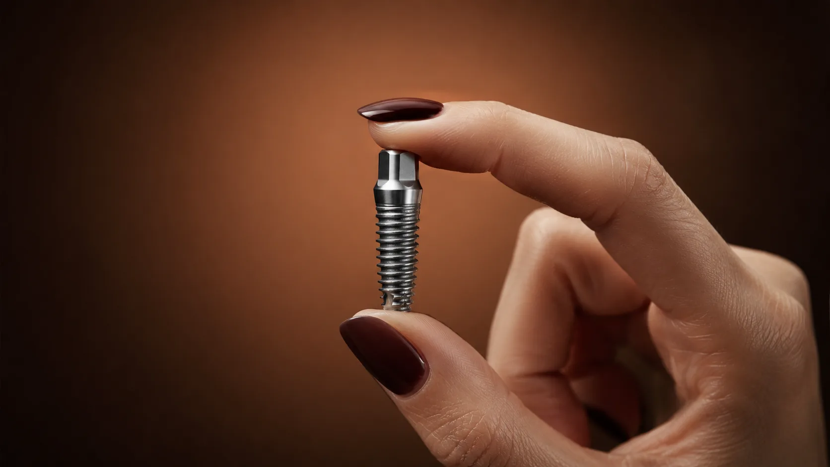 Implant dentar din titan ținut între degete, hiSmile Galați